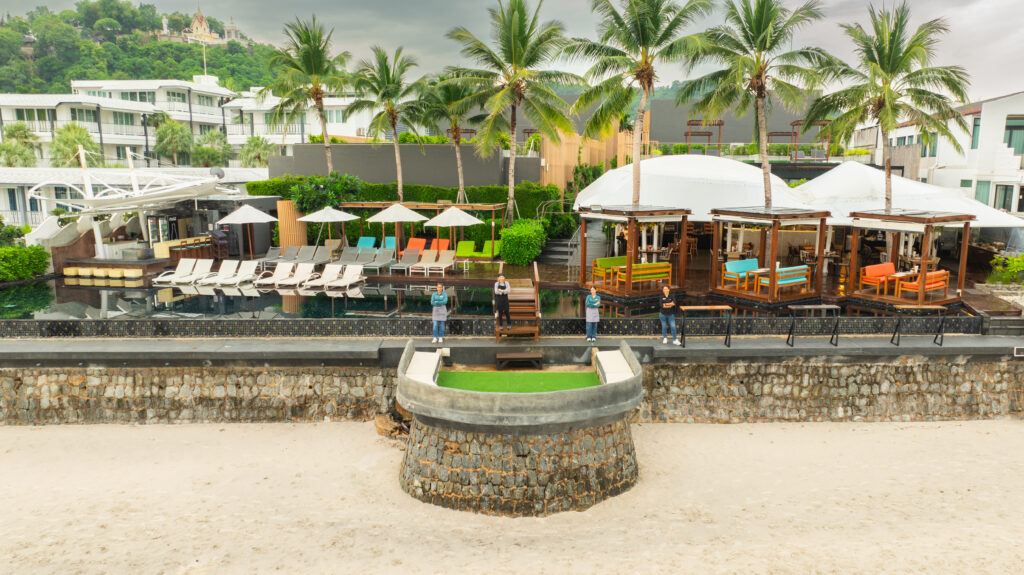 The Yana Villas infinity pool and beach cabanas seen from the sand at Khao Takiab Beach